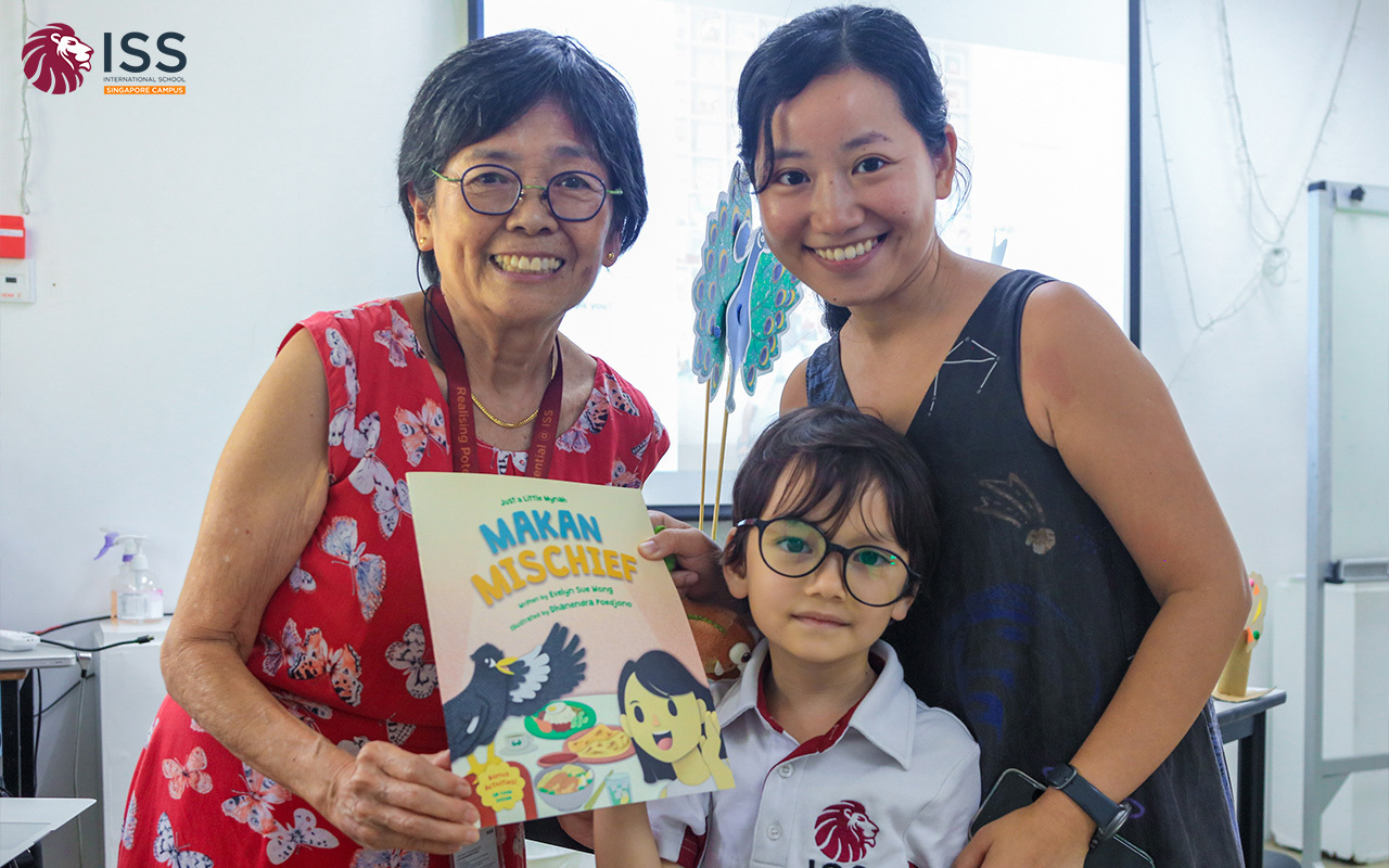 Author and illustrator engaging with an ISS student.