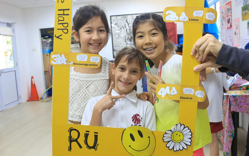 Students smiling together during a school wellbeing awareness activity.