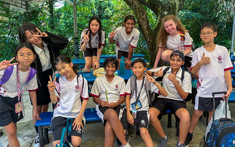 Diverse international school students smiling together outdoors.