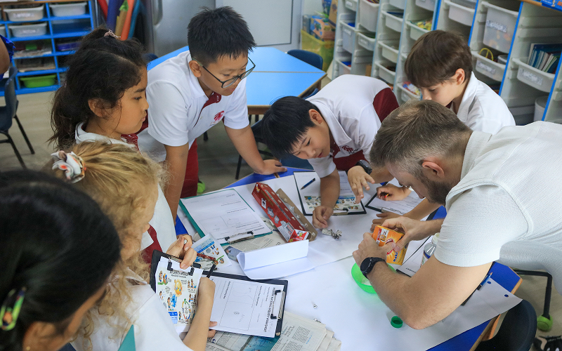 Teacher guiding students during an interactive hands-on classroom activity.