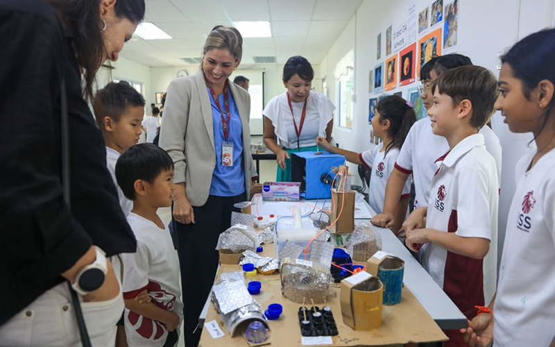 ISS teachers and staff engaging students during a science project.